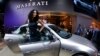A hostess stands next to a Maserati Quattroporte during the first press day of the 65th Frankfurt Auto Show in Frankfurt, Germany, Sept. 10, 2013.