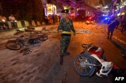 A Thai soldier ropes off the scene after a bomb exploded outside a religious shrine in central Bangkok late on Aug. 17, 2015 killing at least 10 people and wounding scores more.