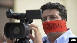 Un camarógrafo protesta el 27 de mayo de 2016 en Cali, Colombia, pidiendo la liberación de dos colegas.