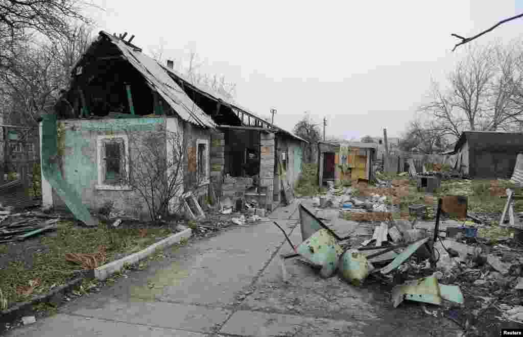 Seorang pria memasuki rumah yang hancur di daerah Spartak, dekat bandar udara internasional Sergey Prokofiev di Donetsk, Ukraina timur (18/11). (Reuters/Antonio Bronic)