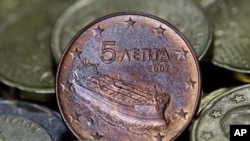 A Greek five-cent euro coin depicting a tanker is seen amongst other coins in Athens, Greece, February 15, 2012.
