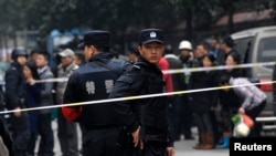 Police stand guard at a crime scene after a knifing incident in Changsha, Hunan province, March 14, 2014. At least three people are dead after the knifing incident in central China's Changsha city, state media reported on Friday, in what appeared to be a 