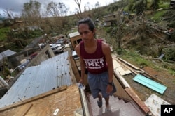 José Colón sube las escaleras de la destruida casa de un amigo luego del huracán María en Aibonito, Puerto Rico. Sept. 25, 2017.