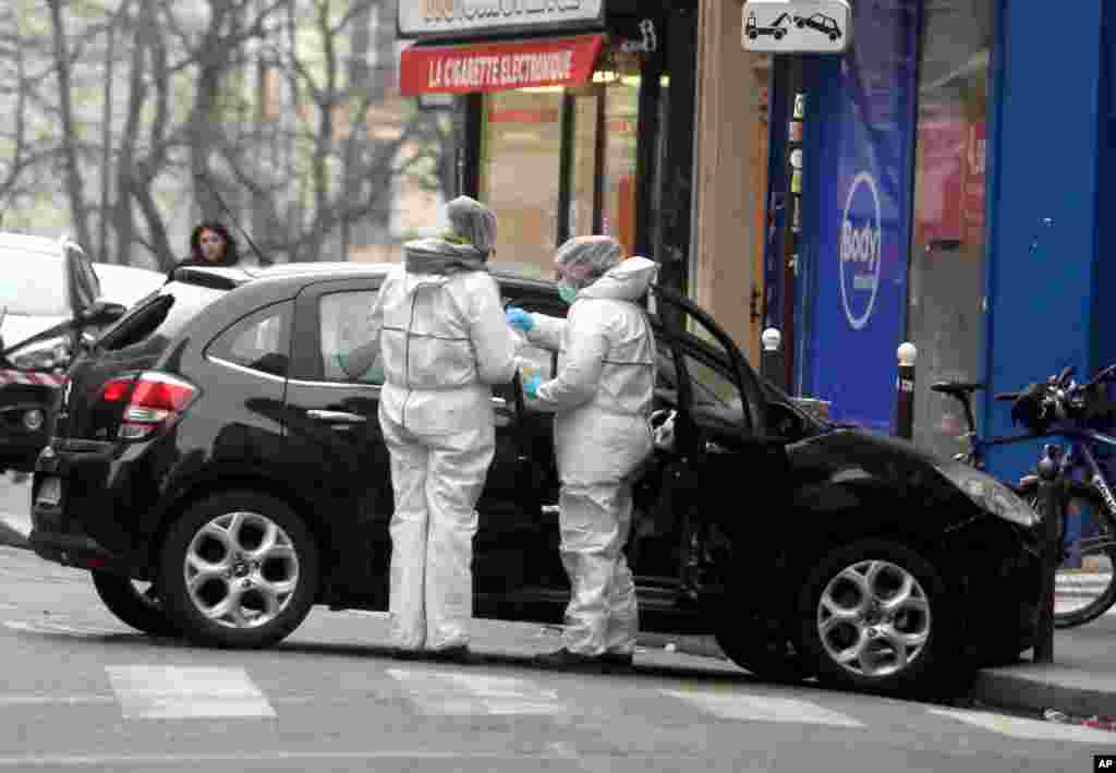 Forensic experts examine the car believed to have been used as the escape vehicle by gunmen who attacked the French satirical weekly Charlie Hebdo&#39;s office in Paris, Jan. 7, 2015.