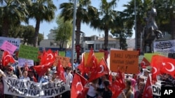 Residents wave national flags as they protest against plans to build a refugee camp under the new EU-Turkey deal in Aegean resort of Dikili, Izmir, Turkey, April 2, 2016. 