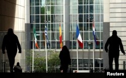 Pedestrians walk toward the European Parliament in Brussels, Belgium, April 30, 2019.