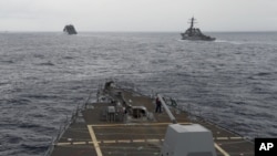 FILE - U.S. Navy ships are seen from the bridge of the guided-missile destroyer USS Spruance, in the South China Sea, Oct. 17, 2016, in a photo provided by the U.S. Navy.