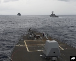 FILE - U.S. Navy ships are seen from the bridge of the guided-missile destroyer USS Spruance, in the South China Sea, Oct. 17, 2016, in a photo provided by the U.S. Navy.