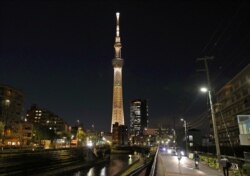 Tokyo Skytree diterangi dengan warna Obor Olimpiade, menandai 100 hari hingga dimulainya estafet obor untuk Olimpiade yang ditunda, Tokyo, Jepang 15 Desember 2020. (Foto:Kyodo via REUTERS)