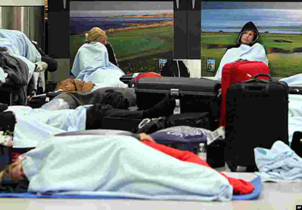 Passengers rest on the floor as their flights have been canceled at Edinburgh Airport in Edinburgh, Scotland, May 24, 2011