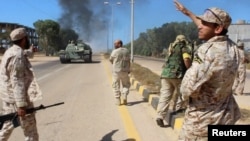 Soldiers from a force aligned with Libya's new unity government walk along a road during an advance on the eastern and southern outskirts of the Islamic State stronghold of Sirte, in this still image taken from video on June 9, 2016. 