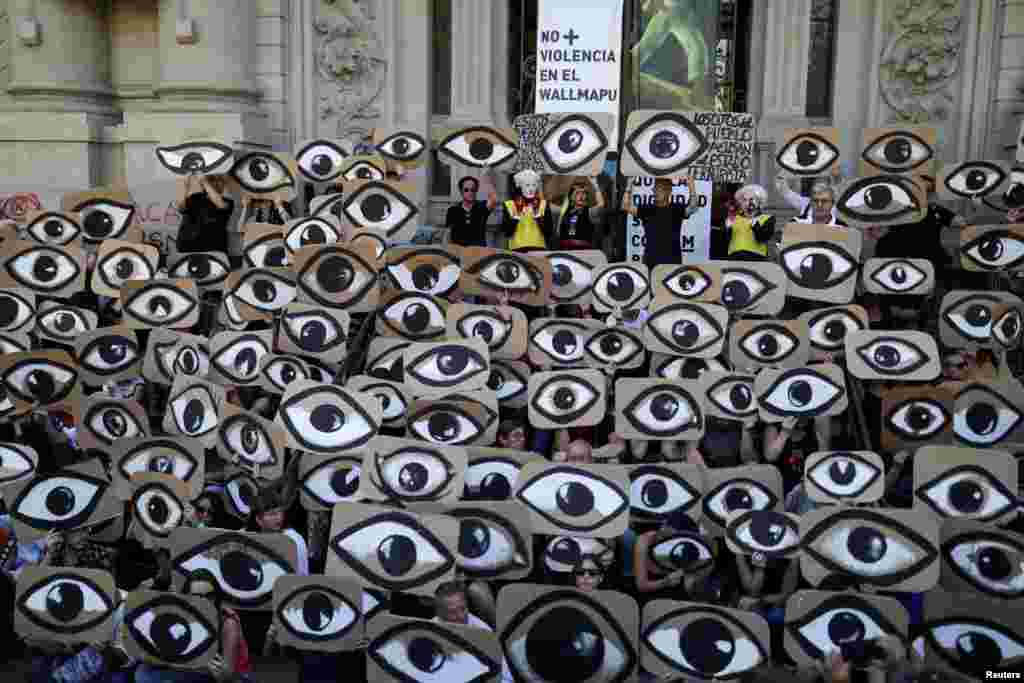 Demonstrators hold signs during a protest against Chile&#39;s government, in Santiago, Dec. 10, 2019.