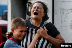 Relatives of inmates held at the General Command of the Carabobo Police react as they wait outside the prison, where a fire occurred in the cells area, according to local media, in Valencia, Venezuela March 28, 2018.