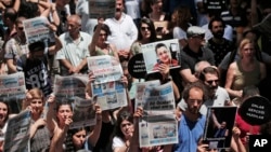 FILE - Protesters demonstrate against the jailing of two journalists and an academic, outside the offices of Ozgur Gundem, a pro-Kurdish publication, in Istanbul, June 21, 2016. 