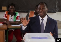 FILE - Ivory Coast's President Alassane Ouattara gestures after casting his ballot during Ivory Cost referendum in Abidjan, Ivory Coast, Oct. 30, 2016.