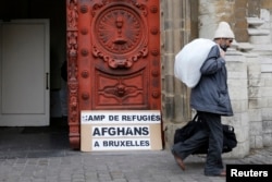 Asylum seeker Abdul Khaleq Homai, 51, from Herat, Afghanistan, walks out the Church of Saint John the Baptist at the Beguinage as he carries clothes to be washed outside the church in central Brussels January 30, 2014. Afghan asylum seekers have been occu