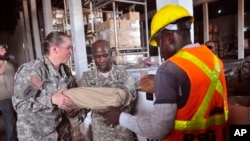 FILE - American soldiers sort through Ebola virus protection equipment to be used in Ebola clinics across the country in Monrovia, Liberia, Nov. 26, 2014. 