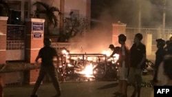 FILE - This June 10, 2018, picture shows protesters burning motorcycles in front of a provincial office in Vietnam's south central coast Binh Thuan province in response to legislation on three special economic zones that would grant 99-year leases to comp