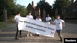 A small group of protesters, from a group called 'Our Future Our Choice', hold a banner at the gate house entrance to Chequers, the Prime Minister's official country residence, near Aylesbury, Britain, July 6, 2018. 