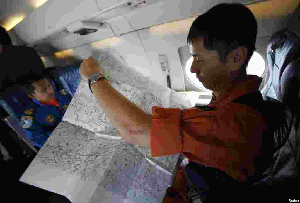 عضو گارد ساحلی ژاپن نقشه ای را که برای عملیات جستجو و نجات جت مسافربری مالزی تهیه شده بررسی می کند - ۱۵ مارس ۲۰۱۴