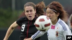 Japan's Mizuho Sakaguchi, right, and United States' Heather O’Reilly (9) chase the ball during the first half of a friendly soccer match in Cary, N.C., May 18, 2011.
