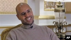 Seif al-Islam Gadhafi, son of Libyan Leader Moammar Gadhafi, smiles during a TV interview in Tripoli in this image taken from TV, March 16, 2011