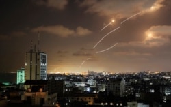 Rockets launched from the Gaza Strip, controlled by the Palestinian Hamas movement, are intercepted by Israel's Iron Dome aerial defence system on May 12, 2021. (Photo by MAHMUD HAMS / AFP