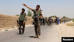 FILE - An Afghan National Army (ANA) soldier gestures as they arrive in Nad Ali district of Helmand province, southern Afghanistan, Aug. 10, 2016. An American soldier died during the operation near the provincial capital of Lashkar Gah, Aug. 23, 2016.