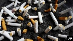 Cigarette butts are discarded in an ashtray outside a New York office building. New York City Mayor Bill de Blasio announced a plan to raise the price of a pack of cigarettes from $10.50 to $13 in the city. (AP Photo/Mark Lennihan)