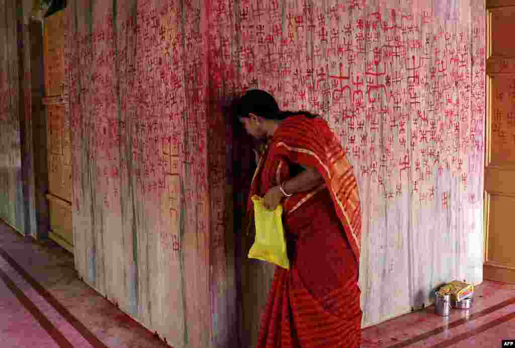 An Indian Hindu woman prays as she takes part in a ritual offering during the Ambubachi festival at a temple in Agartala, the capital of northeastern state of Tripura.