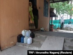 Kadeeja Lavanakkal (R) and her daughter Ruksana wait outside their home for the drinking water supply to start on Kavaratti island, the capital of India's Lakshadweep islands, May 6, 2018.