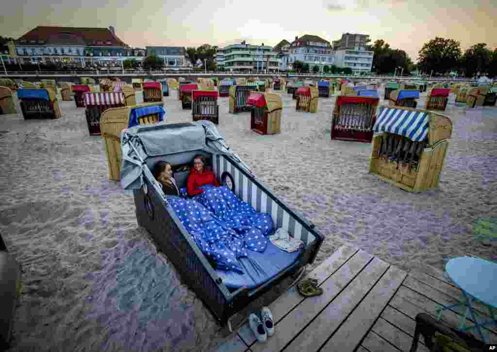 Two young women prepare to spend the night in a specially designed beach chair at the beach of the Baltic Sea in Travemuende, Germany, July 18, 2021.