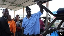 Papiss Sadio, left, stands next to another driver in the main truck garage in the southern Senegalese city, Ziguinchor