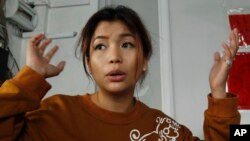 Cambodian actress Ek Socheata, 28, alias Sasa, gestures during an interview to the Associated Press at her clothing shop, in Phnom Penh, Cambodia, Thursday, July 16, 2015. In the grainy black-and-white video the tycoon is seen dragging the actress off a 