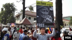 File Photo: A protester is holding a sign that reads 'Free the Activists'