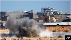 An explosion is seen near Muammar Gadhafi's main compound in the Bab al-Aziziya district in Tripoli, Libya, Tuesday, Aug. 23, 2011