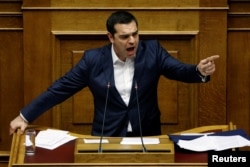 Greek Prime Minister Alexis Tsipras addresses lawmakers during a parliamentary session before a vote on an accord between Greece and Macedonia changing the former Yugoslav republic's name in Athens, Greece, Jan. 24, 2019.