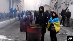 Supporters of former Georgian President Mikheil Saakashvili warm themselves at a fire as they gathered in a narrow street outside the police station where he was taken in Kyiv, Ukraine, Dec. 9, 2017. 