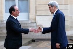 French President Francois Hollande, left, welcomes US Secretary of State John Kerry upon arrival at the Elysee Palace, in Paris, France, Nov. 17, 2015.