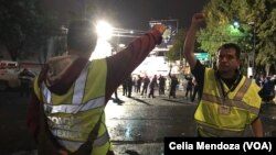 Volunteers working with the rescue teams in Mexico City signal to keep silent. The close fist is a sign to be quiet in order for the rescuers to listen and identify the location of survivors.