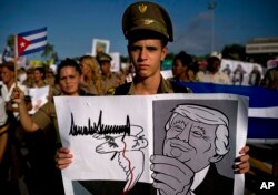 A Cuban soldier carries a cartoon depiction of President Donald Trump during the annual May Day parade held in Revolution Square in Havana, Cuba, May 1, 2019.
