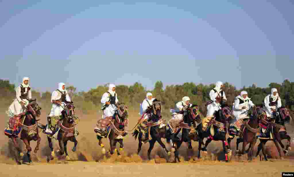 Men, dressed in folk costumes, ride on horses during Eid al-Fitr, which marks the end of the holy month of Ramadan, in Benghazi, Libya, Aug. 9, 2013.