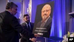 FILE - Mongi Dhaouadi, left, and Ahmed Bedier set up an image of slain Saudi journalist Jamal Khashoggi before an event to remember Khashoggi, a columnist for The Washington Post who was killed inside the Saudi Consulate in Istanbul.