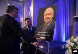 FILE - Mongi Dhaouadi, left, and Ahmed Bedier set up an image of slain Saudi journalist Jamal Khashoggi before an event to remember Khashoggi, a columnist for The Washington Post who was killed inside the Saudi Consulate in Istanbul.