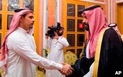 FILE - In this photo released by Saudi Press Agency, SPA, Saudi Crown Prince Mohammed bin Salman, right, shakes hands with Salah Khashoggi, son of Jamal Khashoggi, in Riyadh, Saudi Arabia, Oct. 23, 2018.