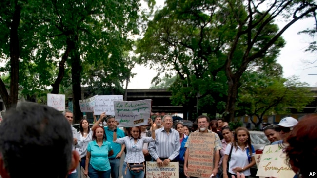 Manifestantes protestan y entonan eslóganes contra el presidente Nicolás Maduro frente una universidad pública en Caracas, Venezuela, el viernes, 28 de abril, de 2018.