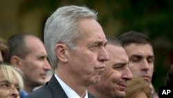 FILE - U.S. Ambassador Hans Klemm, center, attends a Holocaust memorial service in Bucharest, Romania, Oct. 8, 2015.