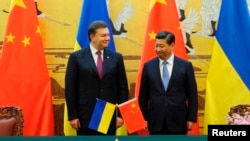 Ukraine's President Viktor Yanukovych (L) and Chinese President Xi Jinping attend a signing ceremony at the Great Hall of the People in Beijing, Dec. 5, 2013.