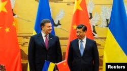 烏克蘭前總統亞努科維奇(左)去年訪問中國﹐與中國國家主席習近平會面。