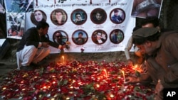 FILE - Afghan residents light candles to pay tribute to Afghan journalists killed in a suicide attack in Kabul, Afghanistan, May 3, 2018. Two Islamic State suicide bombers struck in Afghanistan's capital, killing 25 people, including nine journalists who had rushed to the scene.